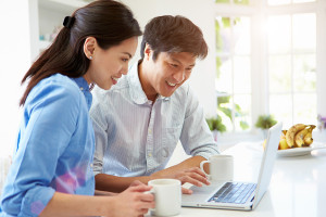 Couple Looking at Laptop In Kitchen