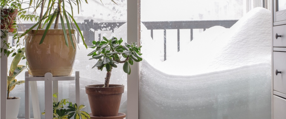 Snowdrift building up outside an apartment balcony door, highlighting key steps for how to prepare for a winter storm in an apartment.