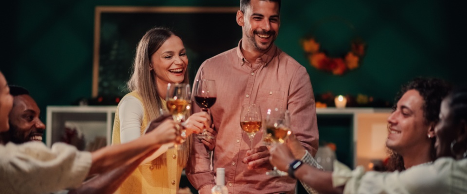 Friends celebrating with drinks at a gathering, reminding renters to consider renters insurance coverage for jewelry during parties and special occasions.