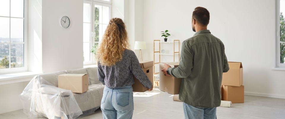 Couple moving into a new apartment with boxes, emphasizing the importance of renters insurance coverage for jewelry and other valuable belongings during a move.