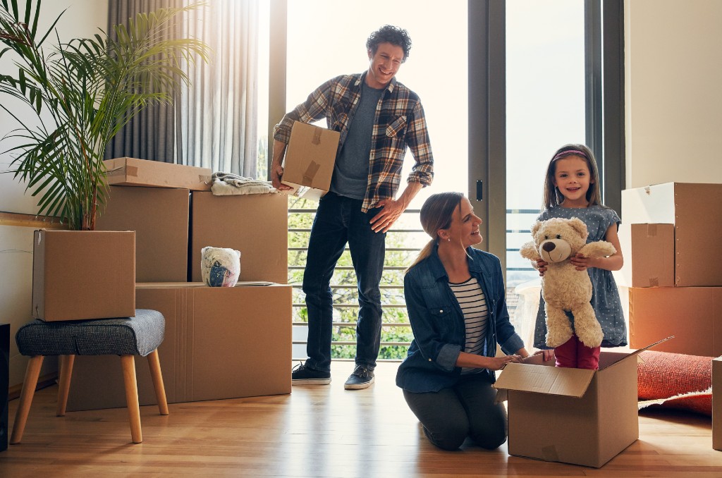 Young family packing boxes in their apartment during a move, illustrating the question: does renters insurance cover moving?