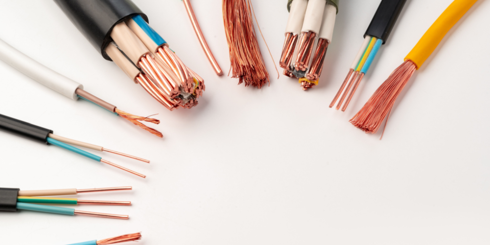 A variety of electrical wires and cables with exposed copper strands, illustrating the importance of following electrical safety tips to prevent accidents at home.