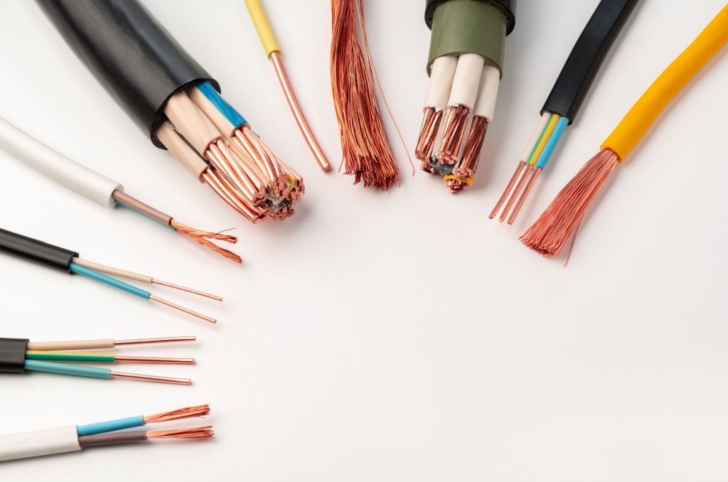A variety of electrical wires and cables with exposed copper strands, illustrating the importance of following electrical safety tips to prevent accidents at home.