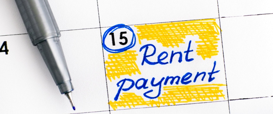 Close-up of a calendar with the 15th circled and "Rent payment" written in blue ink, showing the importance of timely payments when considering guarantor versus cosigner options for rental agreements.