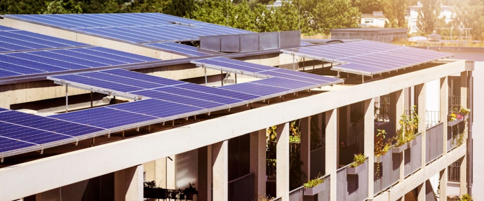 Modern apartment building with rooftop solar panels and a high energy efficiency rating.