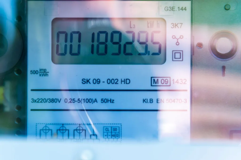 A close-up shot of a digital smart electricity meter installed on a modern home wall.