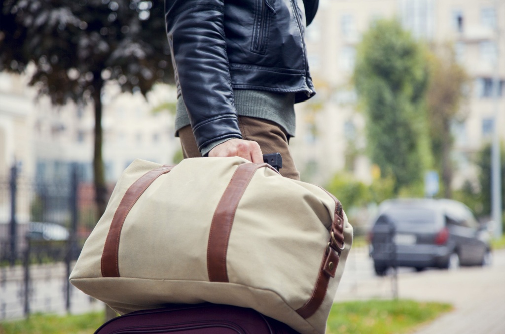 Person carrying a travel bag after leaving home, representing how renters insurance covers displacement and provides temporary living support.