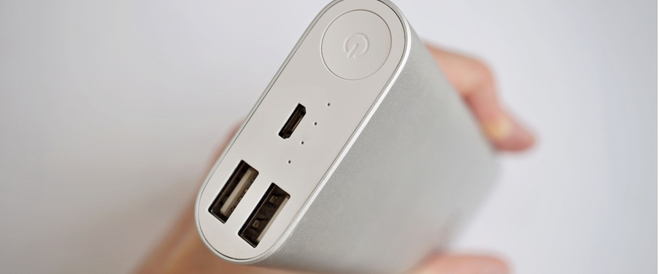 Close-up of a handheld power bank with USB ports, highlighting compact devices that can be used as backup power for your apartment.