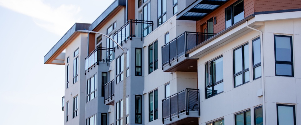 Exterior view of a modern apartment building with balconies, showing property types commonly covered under renters insurance in homeowners versus renters insurance comparisons.