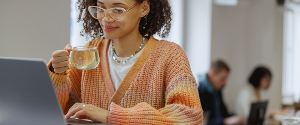 Freelancer working on a laptop while managing finances, illustrating how income stability affects how much of income should go to rent.
