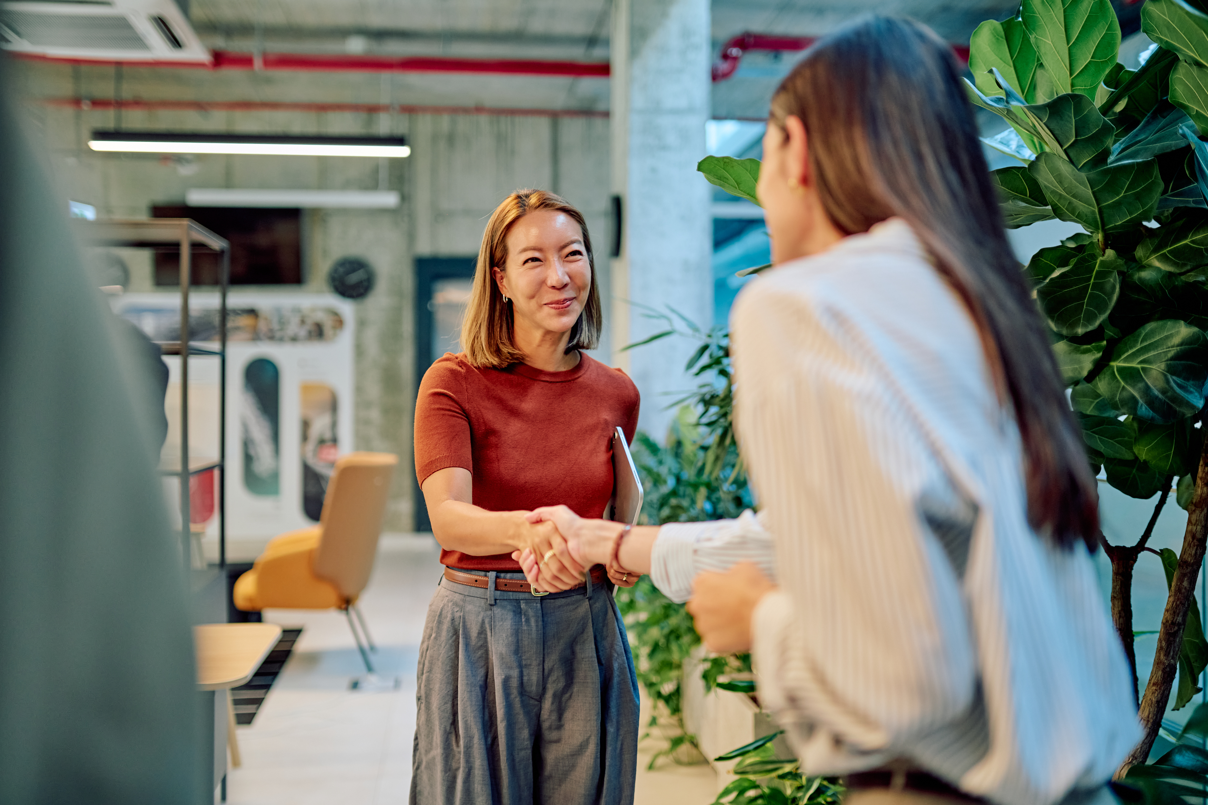 Two people shaking hands in a modern office