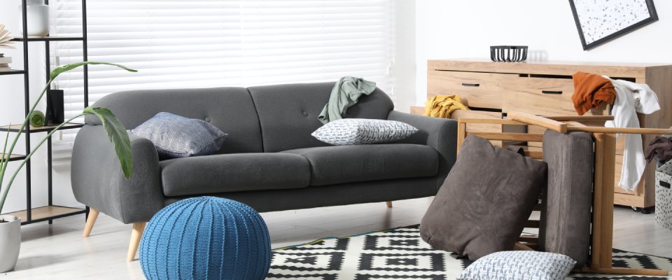 Apartment living room with overturned furniture and scattered belongings, illustrating the personal property coverage types included in renters insurance in Georgia after a break-in.
